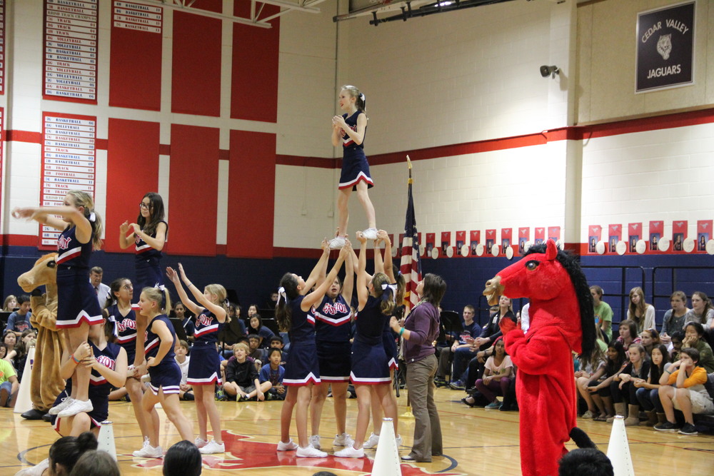 8th grade cheerleader Caelin B. was atop the pyramid at the Veteran's Day pep rally on November 11th. Photo by Yearbook Staff 