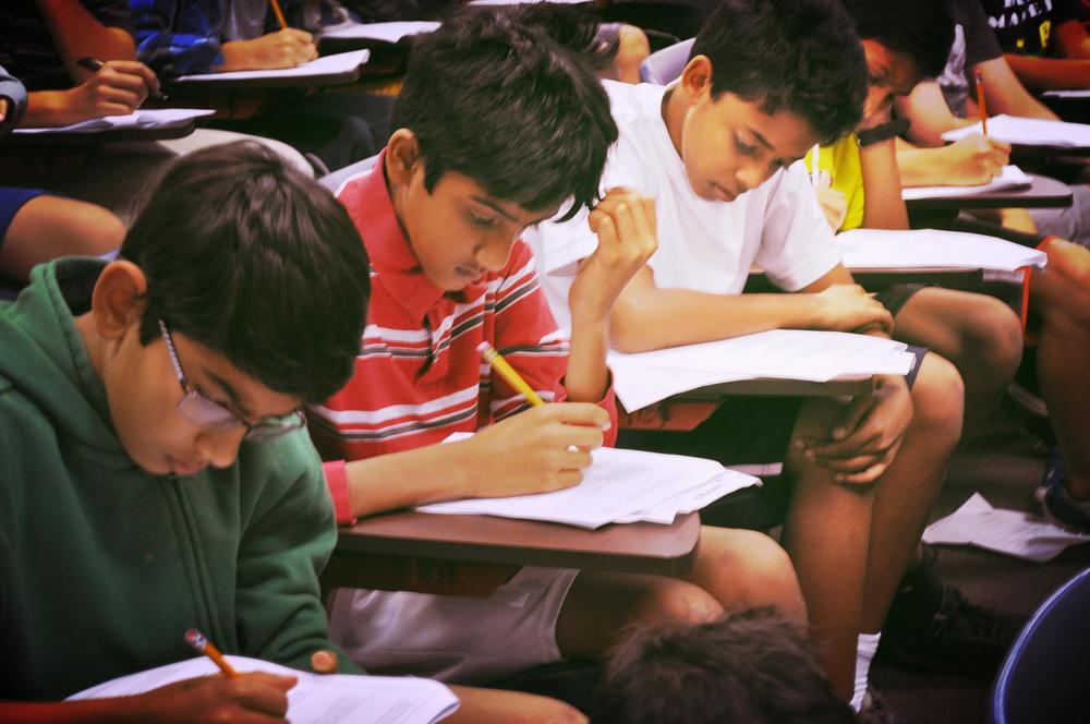 Sixth graders Toshaan A., Ananth K., Rahul K., and Shreyes K. solve math problems at a MATHCOUNTS meeting. Photo by Julie