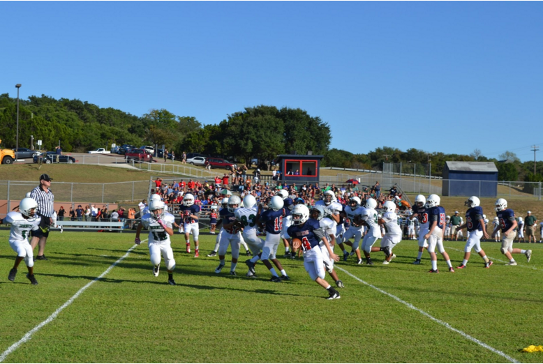 7th grader quarterback Harrison Jaeger turns upfield as he runs the ball. The mustangs had some big plays but it didn’t show on the scoreboard. Photo by Rohan Gupta.