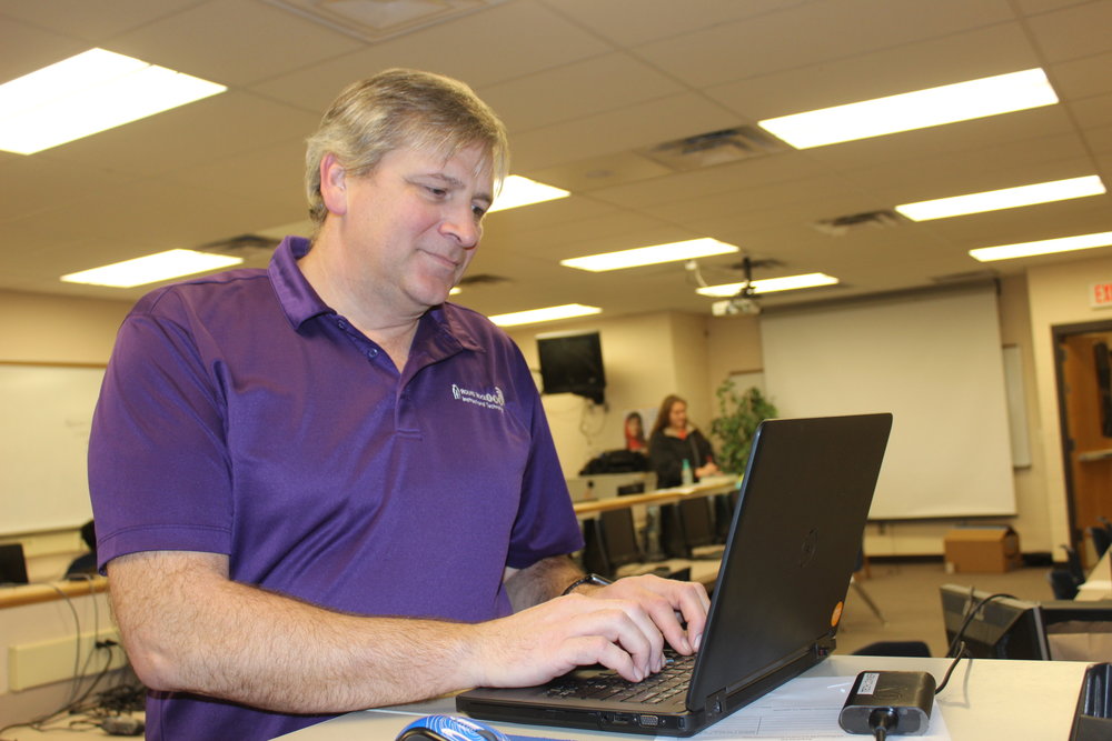 Mr. Powell works everyday in the computer lab to make sure all campus technology is up and working. Photo by Andrew Yao