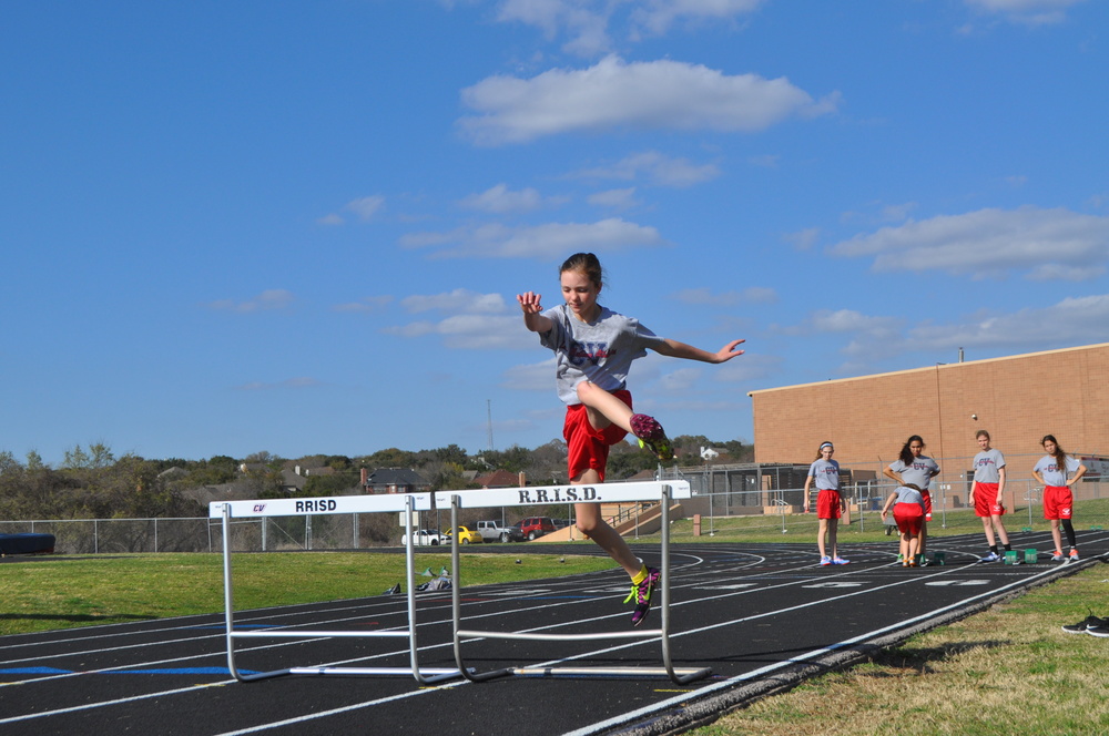 8th grader Anna Christiansen leaps over hurdles during practice. Photo by Michelle Lee