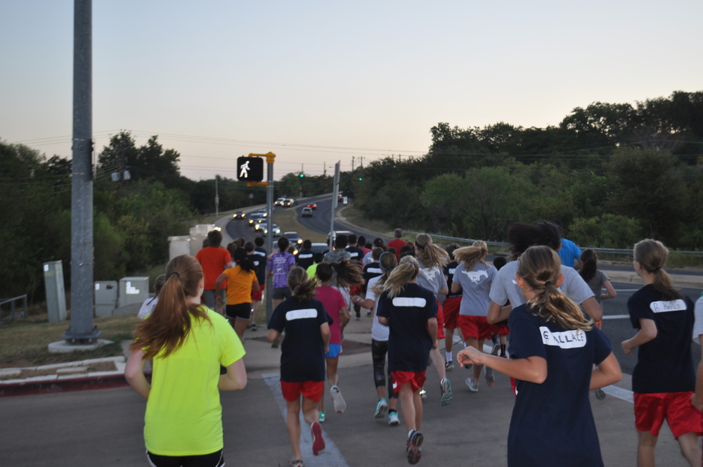 Students race up the Spicewood Springs Road hill as they begin their 1.79 mile run in the neighborhood. Photo by Gabe Kotick