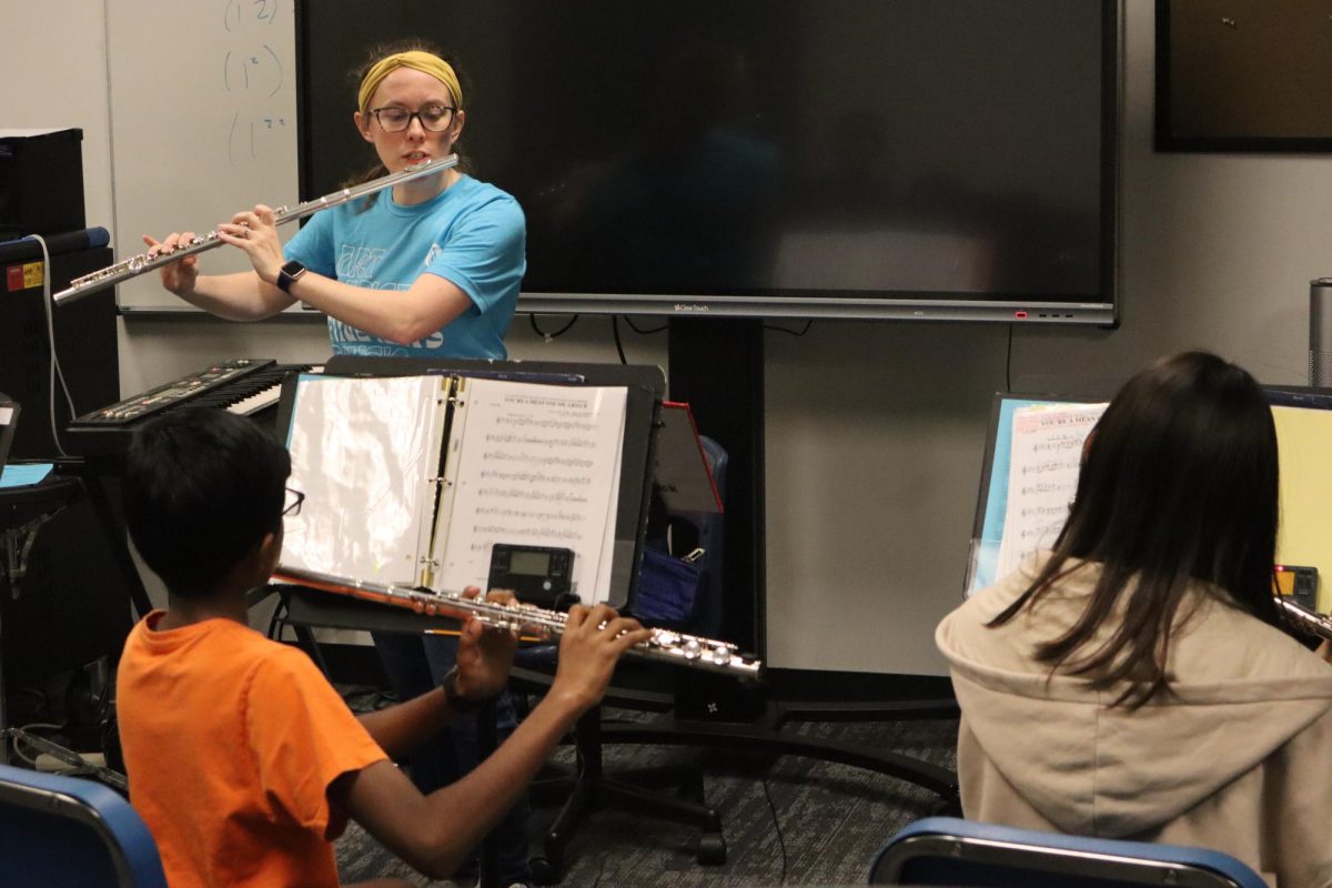 Mrs. Click playing the flute to help select flutes understand a rhythm.