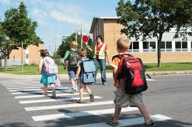 Kids geting help safely walking to school.